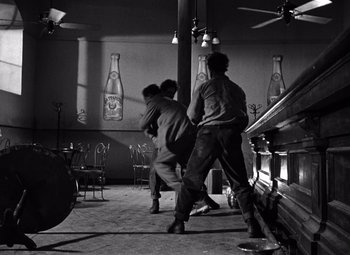 Movie still from “The Treasure of the Sierra Madre” (1948), directed by John Huston – A group of people standing in a room; Wide shot, Low angle