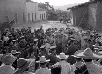 Movie still from “The Treasure of the Sierra Madre” (1948), directed by John Huston – A group of men standing next to each other on a dirt road; Wide shot, Over the shoulder angle