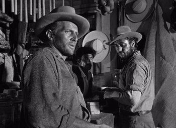 Movie still from “The Treasure of the Sierra Madre” (1948), directed by John Huston – A black - and - white photo of two men wearing hats; Medium shot, Over the shoulder angle