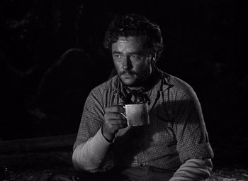 Movie still from “The Treasure of the Sierra Madre” (1948), directed by John Huston – A black and white photo of a man drinking a cup of coffee; Medium shot, Low angle