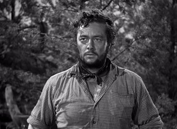 Movie still from “The Treasure of the Sierra Madre” (1948), directed by John Huston – Black and white photograph of a man in a plaid shirt; Close Up shot, Low angle