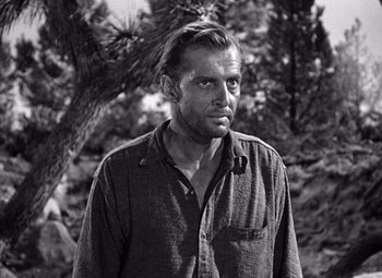 Movie still from “The Treasure of the Sierra Madre” (1948), directed by John Huston – Black and white photograph of a man in front of a tree; Close Up shot, Over the shoulder angle
