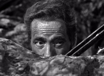 Movie still from “The Treasure of the Sierra Madre” (1948), directed by John Huston – A black - and - white photo of a man's face; Close Up shot, High angle