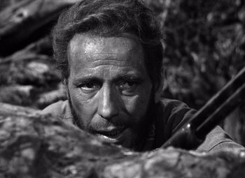 Movie still from “The Treasure of the Sierra Madre” (1948), directed by John Huston – Black and white photograph of a man in the woods; Close Up shot, Low angle
