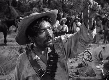 Movie still from “The Treasure of the Sierra Madre” (1948), directed by John Huston – A man in a cowboy hat holding a pocket watch; Close Up shot, Low angle