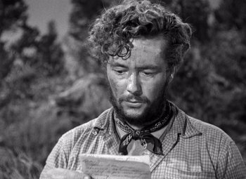 Movie still from “The Treasure of the Sierra Madre” (1948), directed by John Huston – A black and white photo of a man looking at a piece of paper; Close Up shot, Over the shoulder angle