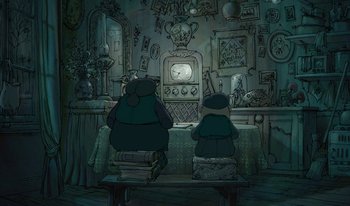 Movie still from “The Triplets of Belleville” (2003), directed by Sylvain Chomet – Two people sitting in front of a television in a living room; Wide shot, High angle