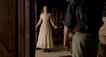 Movie still from “The Village” (2004), directed by M. Night Shyamalan – A woman in a long white dress holding a knife; Medium shot, Low angle