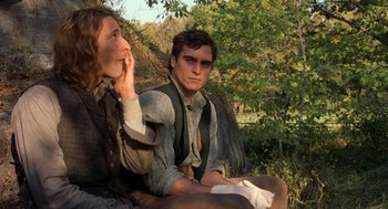Movie still from “The Village” (2004), directed by M. Night Shyamalan – A man and a woman sitting next to each other on a bench; Medium shot, Over the shoulder angle