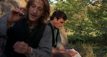 Movie still from “The Village” (2004), directed by M. Night Shyamalan – Two men sitting in the grass writing on paper; Close Up shot, Over the shoulder angle