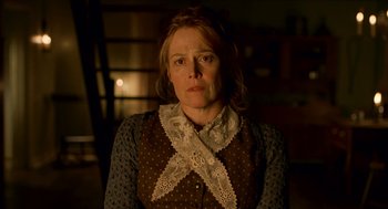 Movie still from “The Village” (2004), directed by M. Night Shyamalan – A woman in a polka dot shirt and a lace scarf; Medium shot, Low angle