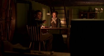Movie still from “The Village” (2004), directed by M. Night Shyamalan – A man and a woman sitting at a table; Medium shot, Over the shoulder angle