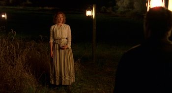 Movie still from “The Village” (2004), directed by M. Night Shyamalan – A woman standing in a field at night; Wide shot, Over the shoulder angle