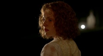 Movie still from “The Village” (2004), directed by M. Night Shyamalan – A young woman with red curly hair wearing a checkered shirt; Close Up shot, Low angle