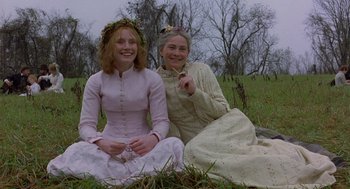 Movie still from “The Village” (2004), directed by M. Night Shyamalan – Two women sitting on the ground in the grass; Medium shot, Low angle