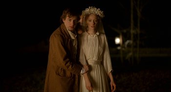 Movie still from “The Village” (2004), directed by M. Night Shyamalan – A man and a woman standing next to each other; Medium shot, Low angle