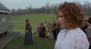 Movie still from “The Village” (2004), directed by M. Night Shyamalan – A group of people standing in a grassy field; Medium shot, Over the shoulder angle