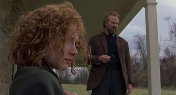 Movie still from “The Village” (2004), directed by M. Night Shyamalan – A man and a woman standing next to each other under an awning; Close Up shot, Low angle