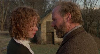 Movie still from “The Village” (2004), directed by M. Night Shyamalan – A man and a woman face to face in front of a stone building; Close Up shot, Low angle