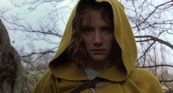 Movie still from “The Village” (2004), directed by M. Night Shyamalan – A woman wearing a yellow hooded cloak and looking at the camera; Close Up shot, Low angle
