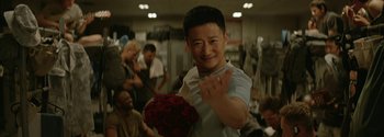 Movie still from “The Wandering Earth II” (2023), directed by Frant Gwo – A young man holding a bouquet of red roses; Medium shot, Over the shoulder angle
