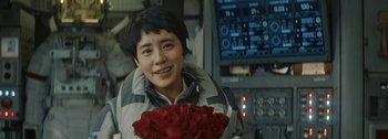 Movie still from “The Wandering Earth II” (2023), directed by Frant Gwo – A young man holding a bouquet of red roses; Close Up shot, Over the shoulder angle