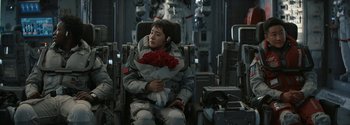Movie still from “The Wandering Earth II” (2023), directed by Frant Gwo – A man sitting in a chair holding a bouquet of roses; Medium shot, Over the shoulder angle