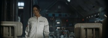 Movie still from “The Wandering Earth II” (2023), directed by Frant Gwo – A man in a white jacket standing in front of a building; Medium shot, Over the shoulder angle