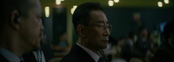 Movie still from “The Wandering Earth II” (2023), directed by Frant Gwo – An older man wearing glasses and a suit; Close Up shot, Over the shoulder angle