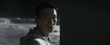 Movie still from “The Wandering Earth II” (2023), directed by Frant Gwo – A man in a grey hoodie is looking at the camera; Close Up shot, Low angle