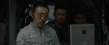 Movie still from “The Wandering Earth II” (2023), directed by Frant Gwo – A man in a gray jacket is looking at a computer screen; Close Up shot, Over the shoulder angle