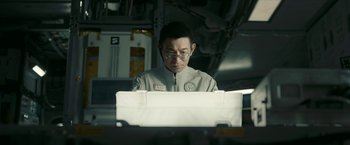 Movie still from “The Wandering Earth II” (2023), directed by Frant Gwo – A man wearing glasses looking at papers on a desk; Close Up shot, Low angle