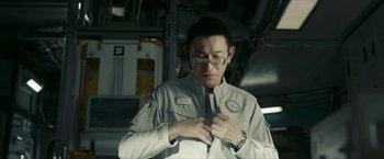 Movie still from “The Wandering Earth II” (2023), directed by Frant Gwo – A man in a white shirt is fixing his tie; Close Up shot, Over the shoulder angle