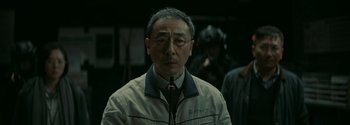 Movie still from “The Wandering Earth II” (2023), directed by Frant Gwo – An older man wearing glasses and a white jacket; Close Up shot, Over the shoulder angle