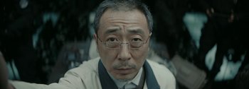 Movie still from “The Wandering Earth II” (2023), directed by Frant Gwo – An older man wearing glasses and wearing a tie; Close Up shot, Low angle