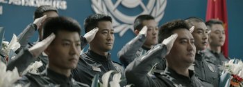 Movie still from “The Wandering Earth II” (2023), directed by Frant Gwo – A group of men saluting in front of a blue wall; Medium shot, Low angle