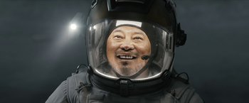 Movie still from “The Wandering Earth II” (2023), directed by Frant Gwo – A man wearing a helmet with a smile on his face; Close Up shot, Low angle