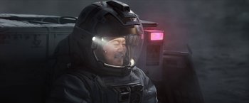 Movie still from “The Wandering Earth II” (2023), directed by Frant Gwo – A man wearing a helmet is sitting in a dark room; Medium shot, High angle