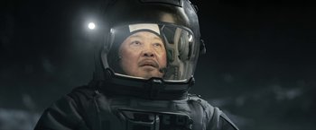 Movie still from “The Wandering Earth II” (2023), directed by Frant Gwo – A man wearing a helmet is looking into a mirror; Close Up shot, Low angle
