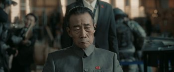 Movie still from “The Wandering Earth II” (2023), directed by Frant Gwo – An older man wearing a gray suit and a red tie; Close Up shot, Over the shoulder angle