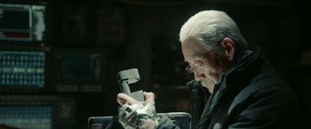 Movie still from “The Wandering Earth II” (2023), directed by Frant Gwo – An older man looking at a phone in a dark room; Close Up shot, Low angle