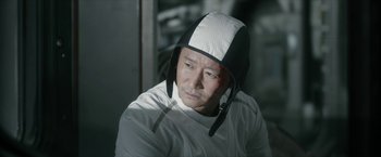Movie still from “The Wandering Earth II” (2023), directed by Frant Gwo – A man wearing a white shirt and a black and white hat; Close Up shot, Low angle