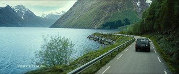 Movie still from “The Wave” (2015), directed by Roar Uthaug – A view of a lake from a moving vehicle; Extreme Wide shot, High angle