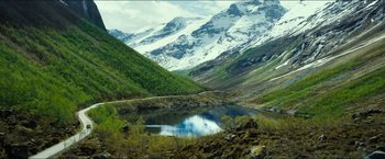 Movie still from “The Wave” (2015), directed by Roar Uthaug – A mountain range with a body of water in the middle of it; Extreme Wide shot, High angle