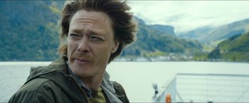 Movie still from “The Wave” (2015), directed by Roar Uthaug – A person wearing a jacket near a body of water; Close Up shot, Low angle