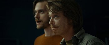 Movie still from “The Wave” (2015), directed by Roar Uthaug – Two men with long brown hair and blue eyes; Close Up shot, Over the shoulder angle