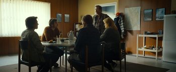 Movie still from “The Wave” (2015), directed by Roar Uthaug – A group of people sitting around a table; Wide shot, Over the shoulder angle