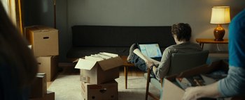 Movie still from “The Wave” (2015), directed by Roar Uthaug – A person sitting in a chair with a laptop; Wide shot, High angle