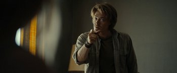 Movie still from “The Wave” (2015), directed by Roar Uthaug – A young man is pointing to his face in the dark; Medium shot, Over the shoulder angle