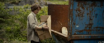 Movie still from “The Wave” (2015), directed by Roar Uthaug – A man holding a box with a bunch of papers in it; Medium shot, Low angle